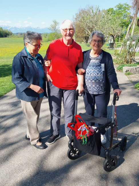 3 ältere Damen vor Bergkulisse, eine mit Rollator