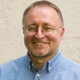 Mann mit Brille und blau kartiertem Hemd